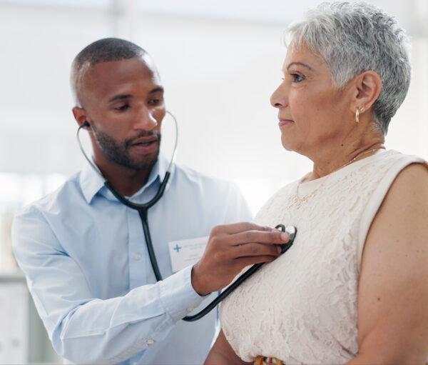 Stethoscope, examination and doctor with senior woman at hospital for lungs, chest or breathing assessment. Heart, listen and elderly patient consulting cardiologist for heartbeat, pulse or checkup
