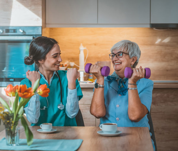 Two women working with hand weights